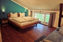 türkises Zimmer mit Balkenbett (180x200) und Sofa mit Schlafoption (140x200)