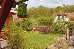 Sonniger grüner Garten mit Kinderspielmöglichkeiten und Hollywoodschaukel